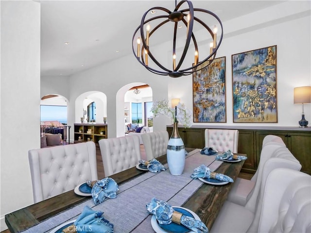 dining room featuring a notable chandelier, recessed lighting, and arched walkways