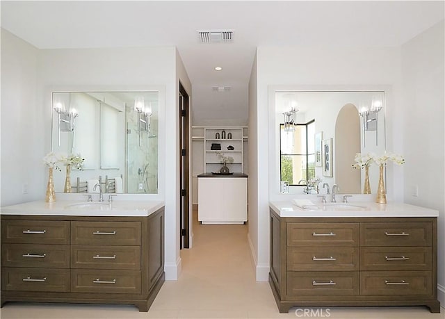 bathroom featuring two vanities, visible vents, and a sink