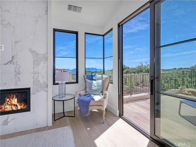 sunroom featuring visible vents and a high end fireplace