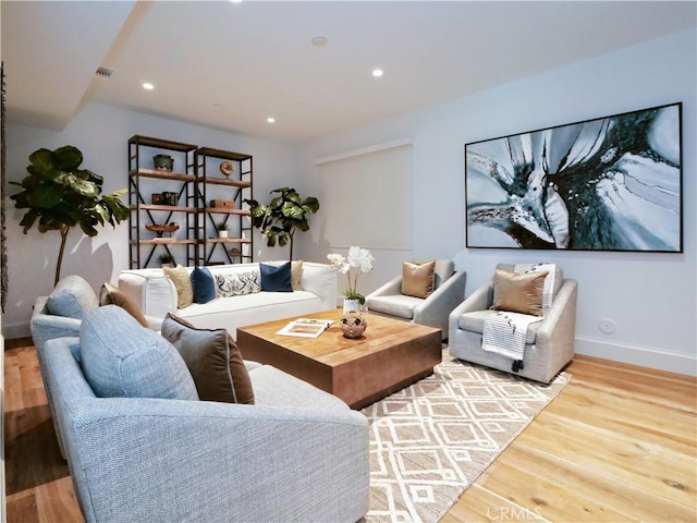 living area with recessed lighting, visible vents, baseboards, and wood finished floors