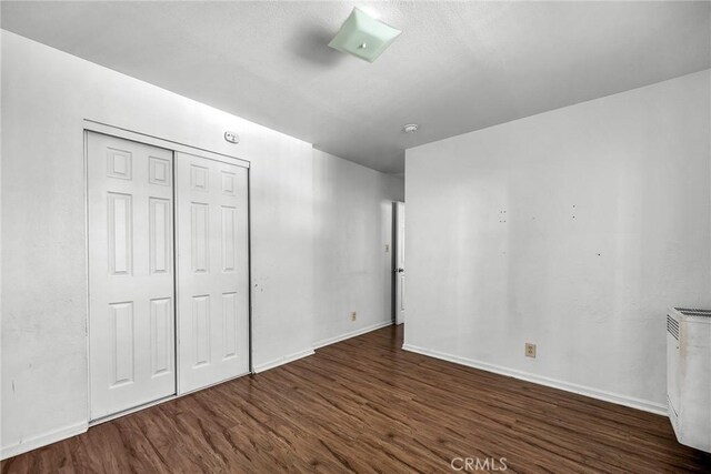 822 E 87th Pl, Los Angeles, CA 90002 - unfurnished bedroom with wood finished floors, baseboards, and a closet
