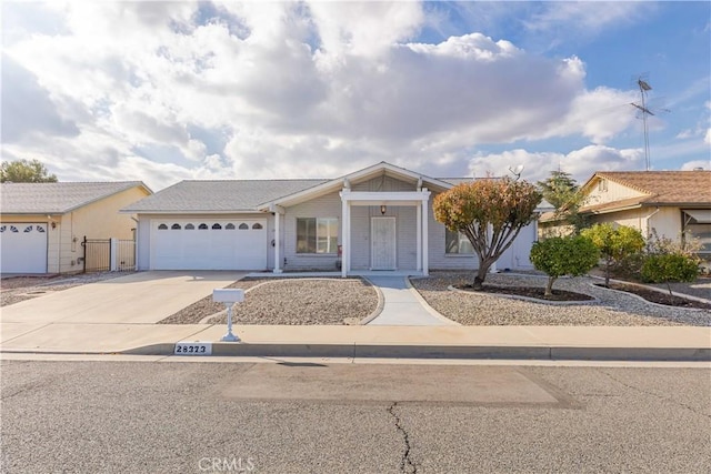 view of front of house featuring concrete driveway, a garage, and fence