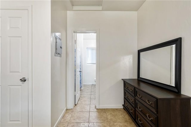 hallway with light tile patterned floors and baseboards