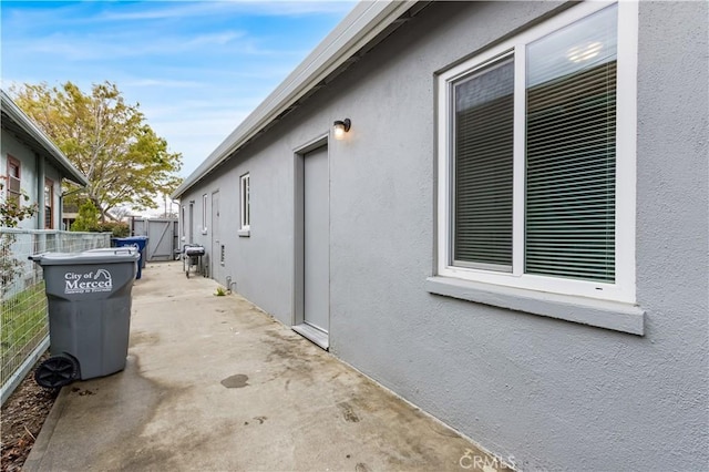 view of home's exterior featuring stucco siding, a patio, and fence