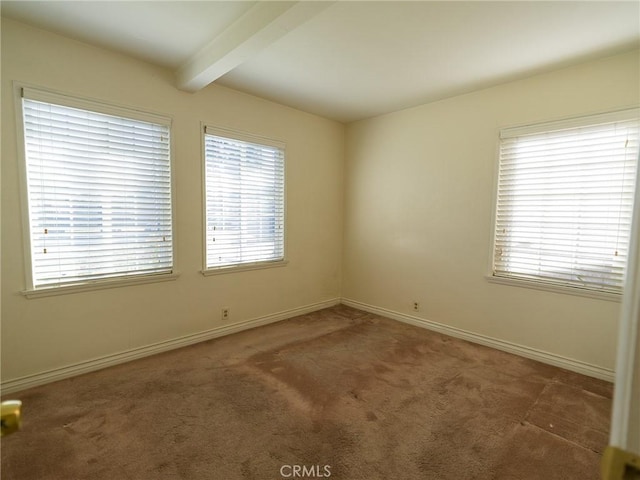 empty room featuring beam ceiling, carpet flooring, and baseboards