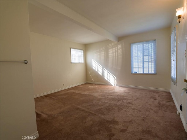 carpeted empty room featuring beam ceiling and baseboards