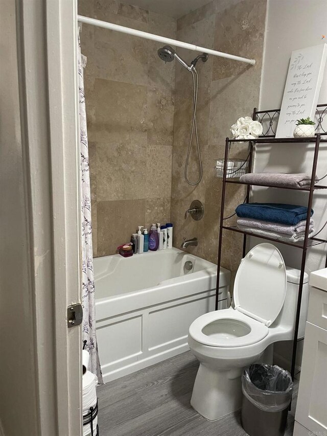 bathroom featuring toilet, wood finished floors, and shower / bath combination with curtain