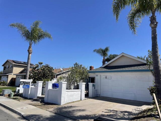 view of front of home featuring stucco siding, driveway, fence private yard, and a garage