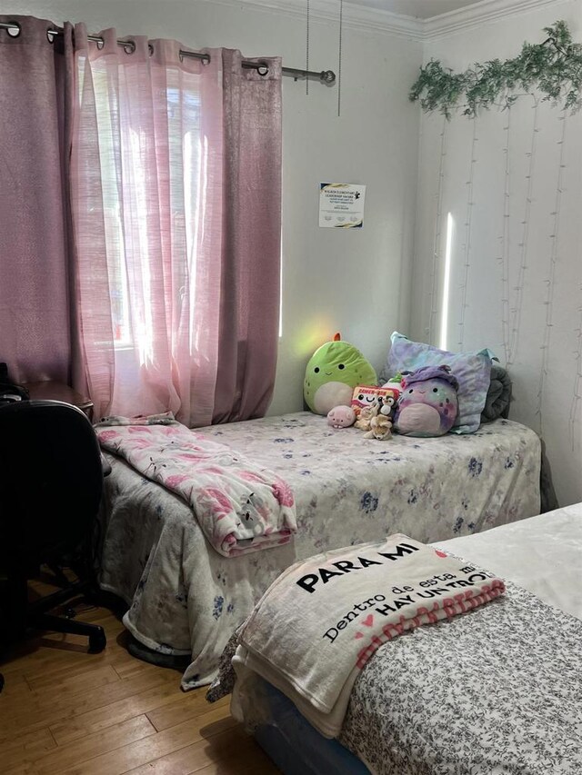 bedroom featuring crown molding and hardwood / wood-style floors