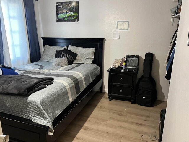 bedroom with baseboards and wood finished floors