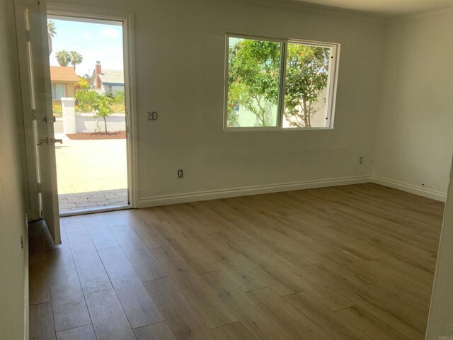 empty room with baseboards and wood finished floors