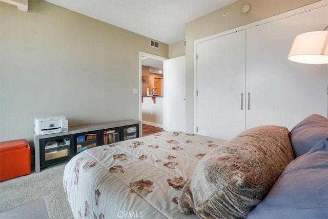 bedroom with a closet, visible vents, and carpet