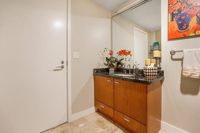 bathroom featuring vanity, baseboards, and tile patterned flooring