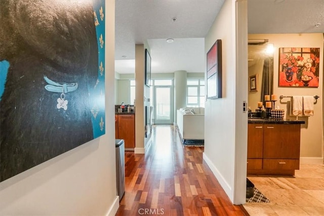 hall featuring wood finished floors and baseboards