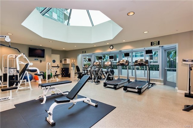 gym with recessed lighting, a skylight, and a high ceiling