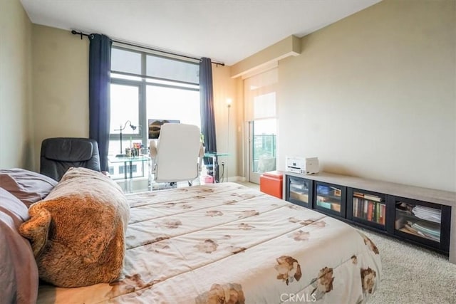 bedroom with a wall of windows and carpet floors