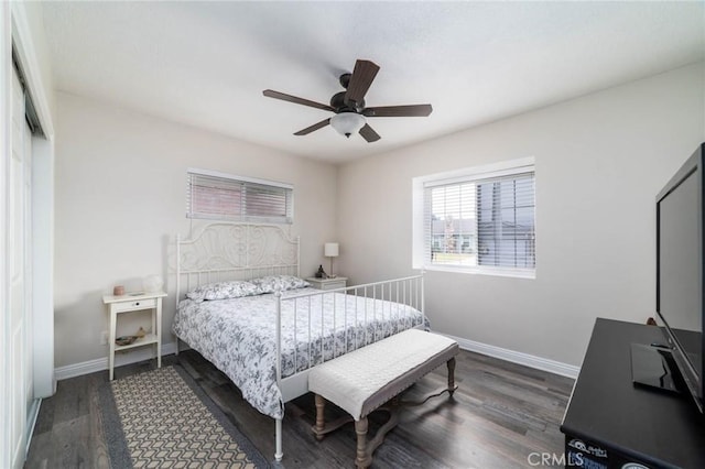 bedroom with baseboards, dark wood-type flooring, and ceiling fan