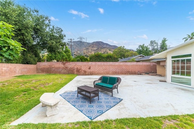 view of patio / terrace featuring a mountain view, outdoor lounge area, and a fenced backyard