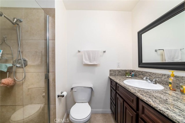 bathroom with baseboards, vanity, toilet, and a shower stall