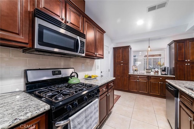 kitchen featuring light tile patterned floors, light stone countertops, visible vents, stainless steel appliances, and tasteful backsplash