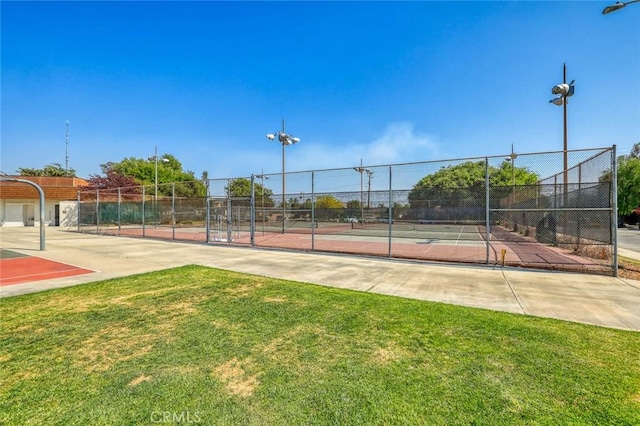 view of sport court with a yard and fence