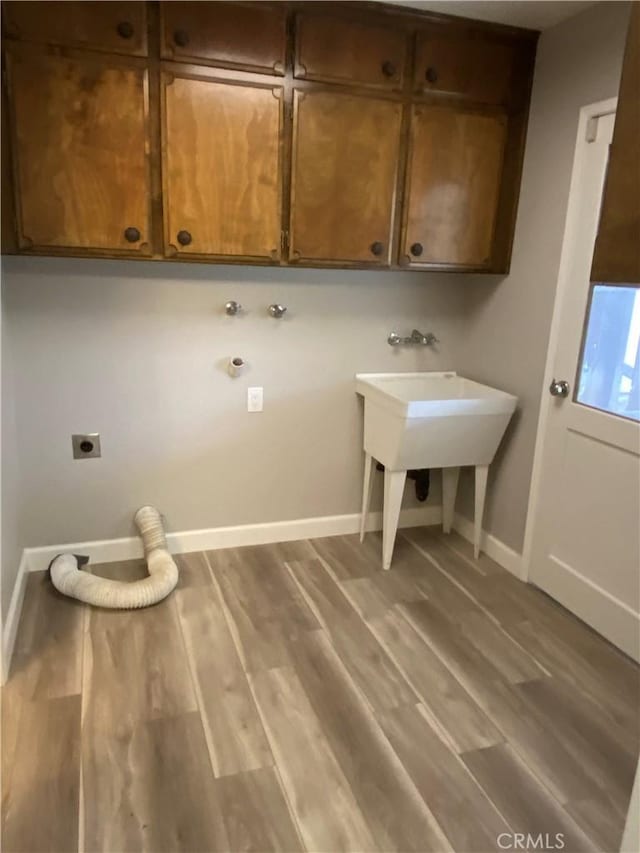 laundry area with hookup for a washing machine, cabinet space, hookup for an electric dryer, and wood finished floors