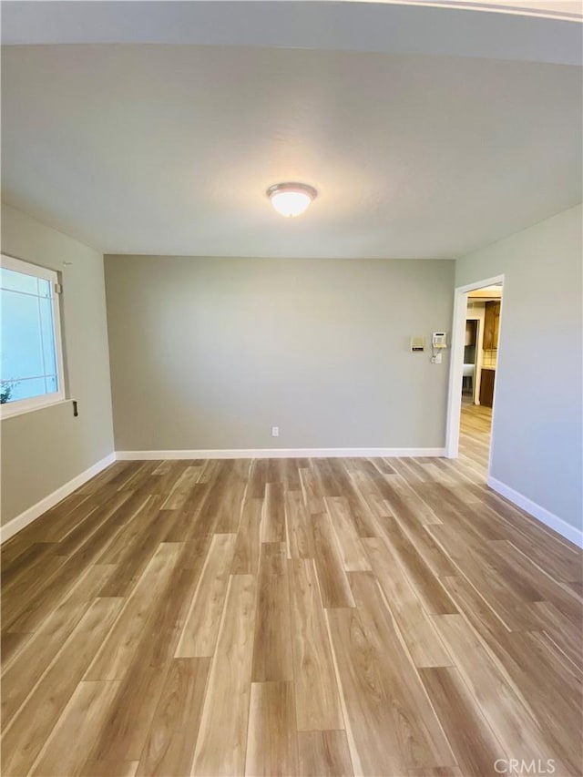 empty room featuring light wood-style flooring and baseboards