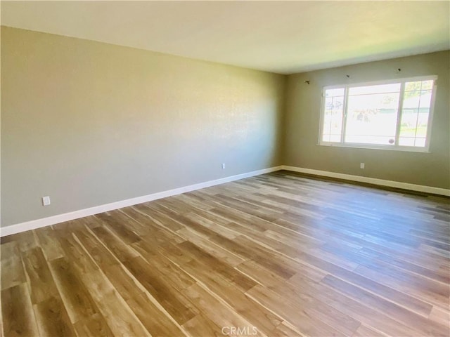 spare room with wood finished floors and baseboards