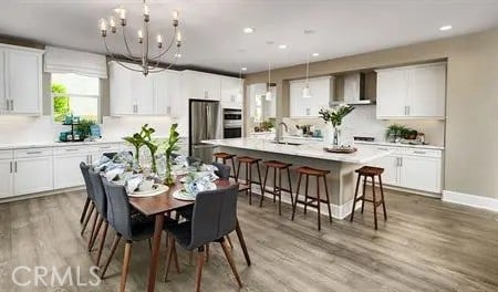 dining space featuring recessed lighting, light wood-type flooring, baseboards, and an inviting chandelier