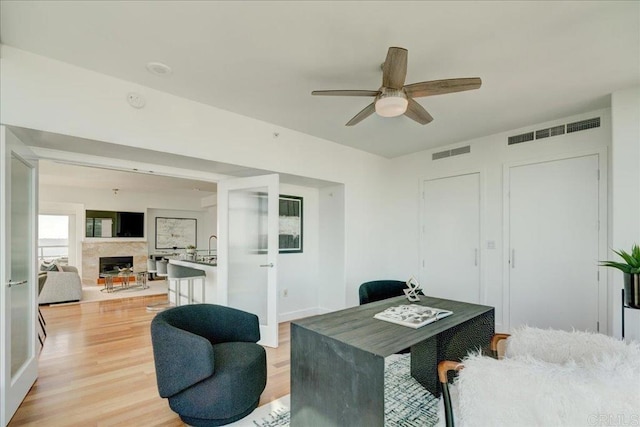 office space with visible vents, light wood-style floors, ceiling fan, and french doors