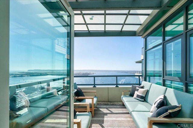 balcony featuring an outdoor living space and a water view