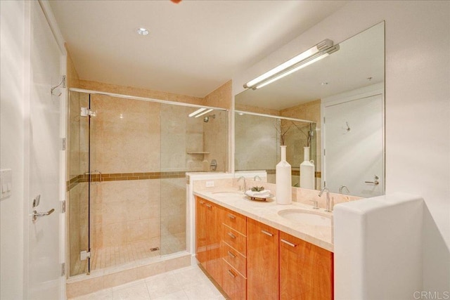 full bathroom with a shower stall, double vanity, and a sink