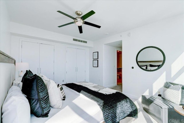 bedroom featuring a ceiling fan, baseboards, visible vents, and light carpet