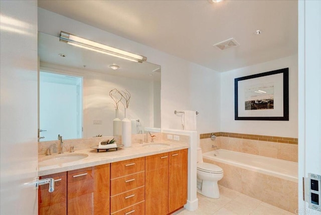 bathroom featuring a bath, double vanity, toilet, and a sink