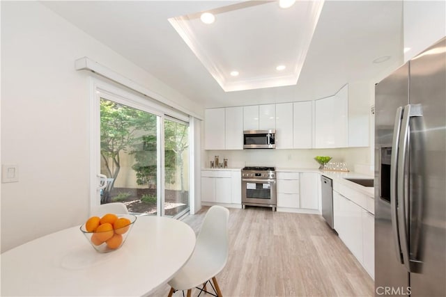 kitchen featuring modern cabinets, recessed lighting, light countertops, white cabinets, and appliances with stainless steel finishes
