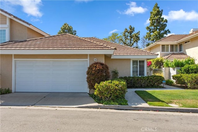 10 Windsong, Irvine, CA 92614 - view of front of property with stucco siding, an attached garage, concrete driveway, and a tile roof