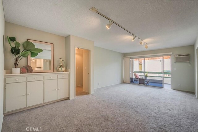 355 S Los Robles Ave Unit 310, Pasadena, CA 91101 - spare room featuring an AC wall unit, light carpet, rail lighting, a textured ceiling, and baseboards