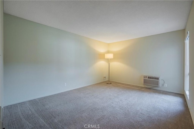 unfurnished room with a wall mounted air conditioner and carpet floors