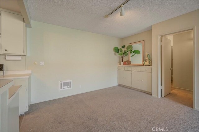 355 S Los Robles Ave Unit 310, Pasadena, CA 91101 - unfurnished dining area featuring light carpet, a textured ceiling, and rail lighting