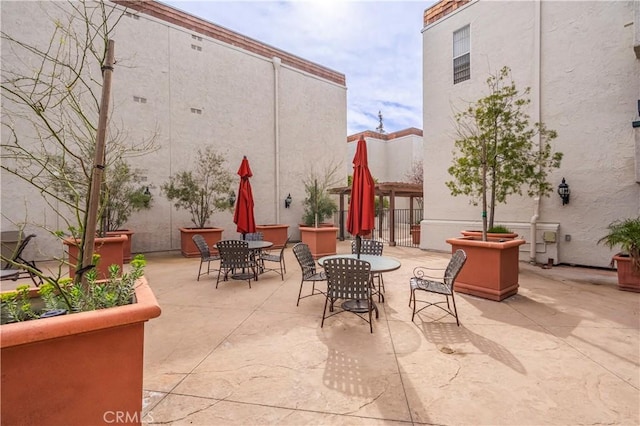 view of patio featuring outdoor dining space and fence