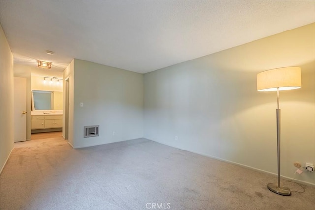 unfurnished bedroom with ensuite bath and carpet flooring