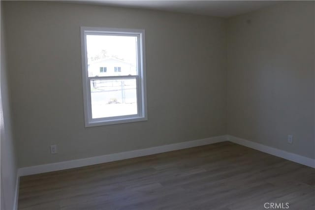 unfurnished room with wood finished floors and baseboards