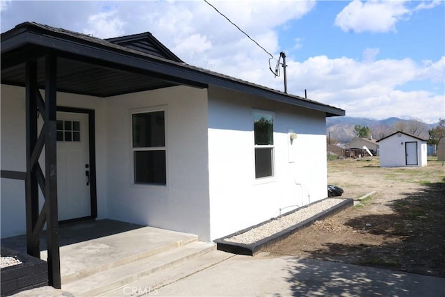 doorway to property featuring stucco siding and a mountain view