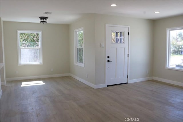 foyer featuring recessed lighting, visible vents, baseboards, and wood finished floors