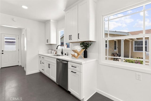 kitchen with a sink, baseboards, dishwasher, and white cabinetry