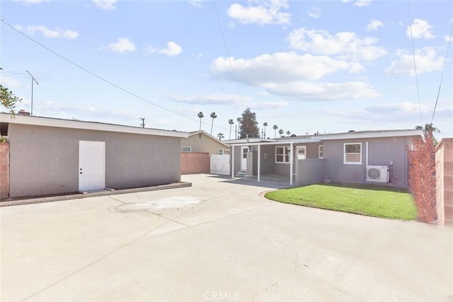 back of house with ac unit, stucco siding, an outbuilding, and fence