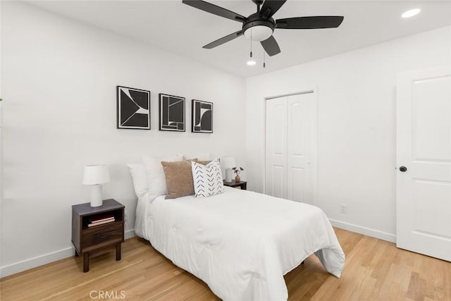 bedroom featuring recessed lighting, baseboards, light wood-type flooring, and a closet