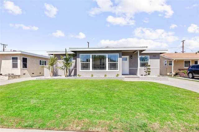 view of front facade featuring stucco siding, driveway, and a front lawn