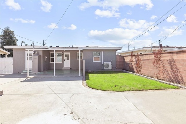 exterior space featuring stucco siding, concrete driveway, a yard, and fence