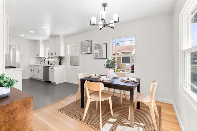 dining room featuring recessed lighting, baseboards, an inviting chandelier, and light wood-style flooring